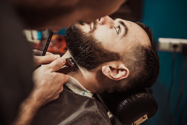 un hombre con barba se está cortando el cabello con un peine