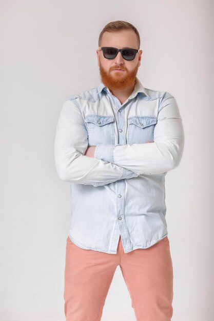 Hombre de barba con gafas de sol y camisa de mezclilla