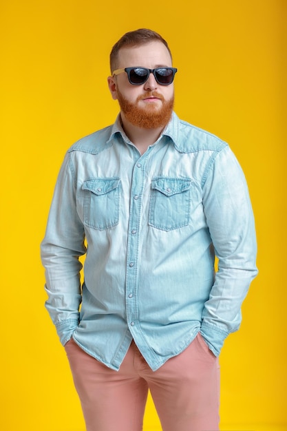 Hombre de barba con gafas de sol y camisa de mezclilla