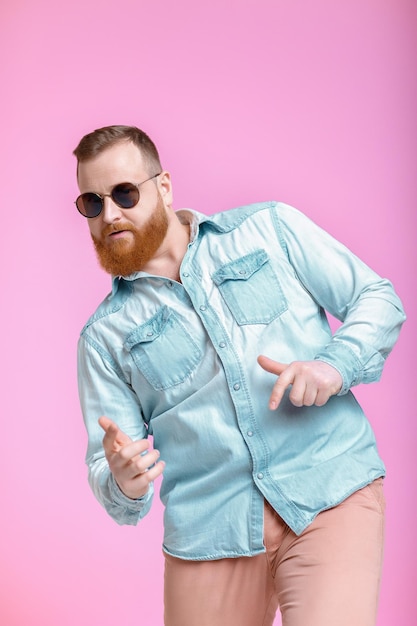 Hombre de barba con gafas de sol y camisa de mezclilla