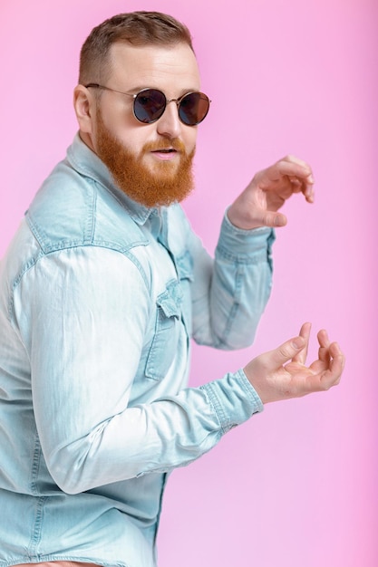 Hombre de barba con gafas de sol y camisa de mezclilla