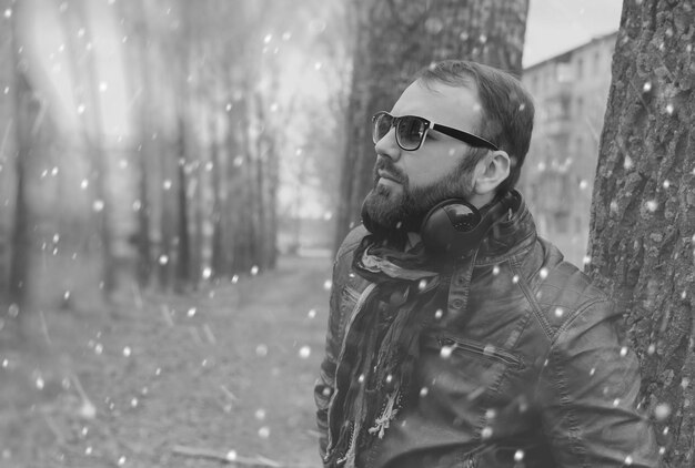 Hombre de barba de invierno en el parque con auriculares