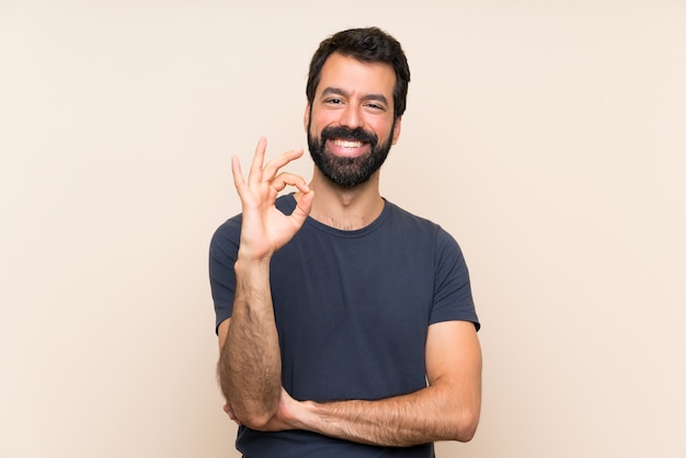 Hombre con barba mostrando signo bien con los dedos