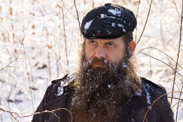 Un hombre con barba en la nieve, con cara de enojo.