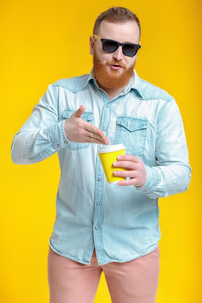 Hombre de barba roja sosteniendo una taza de café