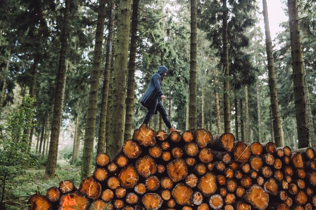 Hombre con barba va sobre madera en el bosque