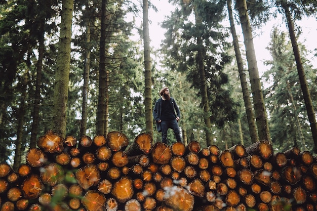 Hombre con barba va sobre madera en el bosque