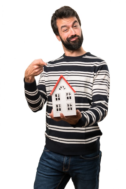 Hombre con barba sosteniendo una casita