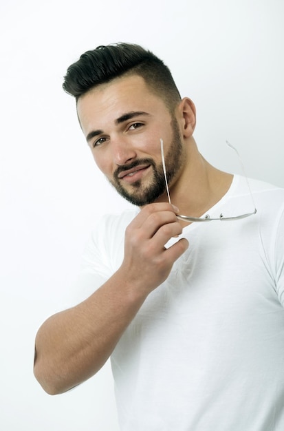 Hombre con barba sosteniendo gafas de sol de aviador vintage en la mano