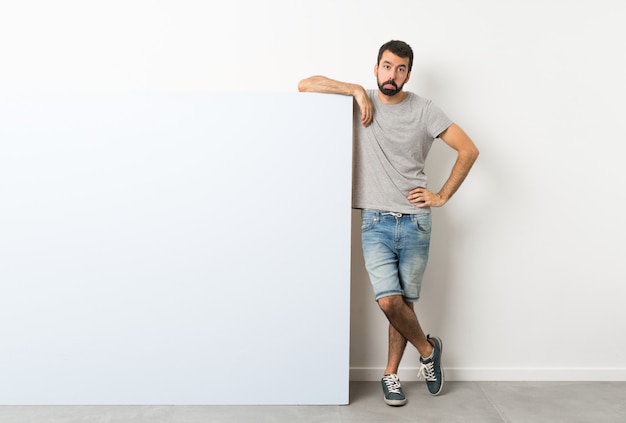 Hombre con barba sosteniendo una gran pancarta