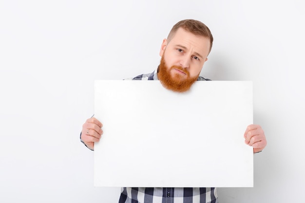 Hombre con barba sosteniendo una gran tarjeta blanca