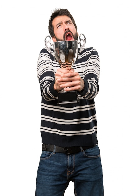 Hombre con barba sosteniendo un trofeo