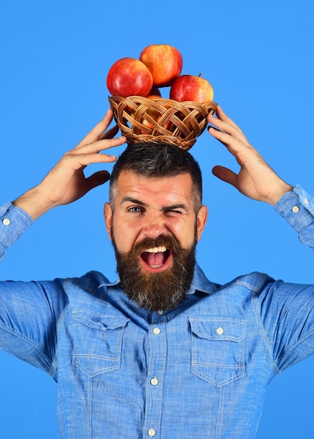 Foto hombre con barba sostiene cuenco de mimbre con fruta