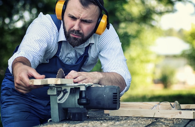 Hombre de barba trabajador con sierra circular