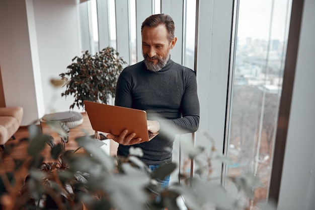 Foto hombre con barba trabajando en una tableta en la oficina