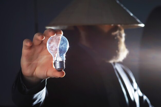 Foto un hombre con barba y traje tiene un objeto en la mano. concepto de tiempo e ideas. aspiración y desarrollo.