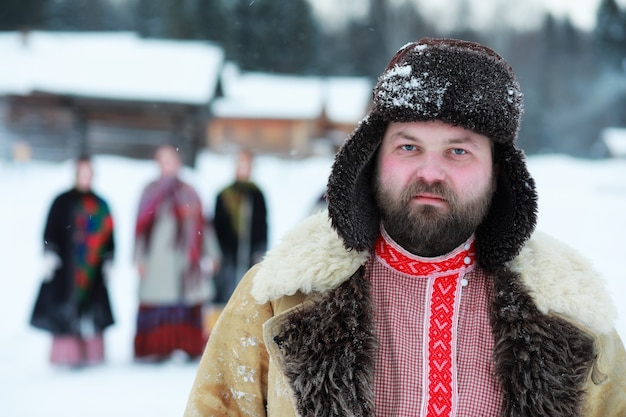 Hombre de barba en traje tradicional de invierno de la edad medieval campesina en Rusia