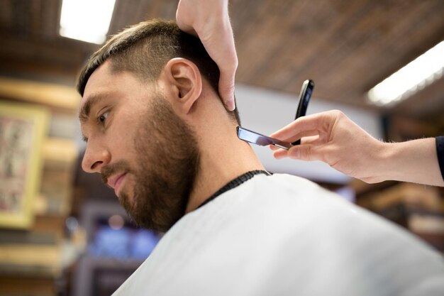 Foto hombre y barbero con el cabello recto de afeitar