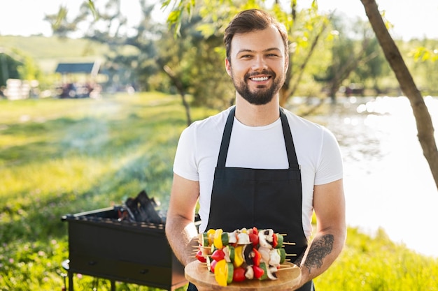 Hombre barbudo alegre con pinzas en el plato