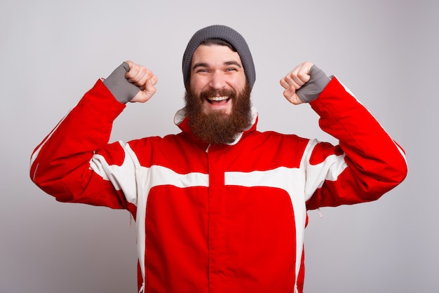 Hombre barbudo alegre en ropa de invierno celebrar