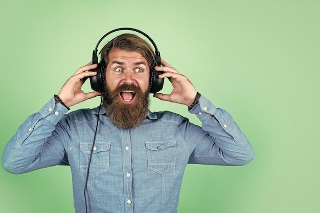 Hombre barbudo con auriculares escucha el concepto de música del audiolibro de educación en línea escucha la canción favorita nueva tecnología en la vida moderna vida digital hipster en auriculares