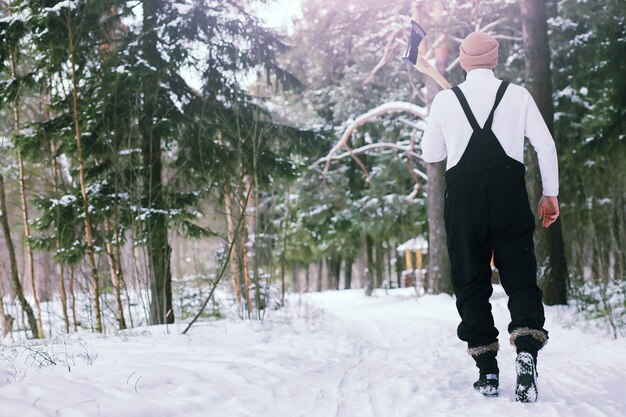 Hombre barbudo en el bosque de invierno. Atractivo joven feliz con barba caminar en el parque.