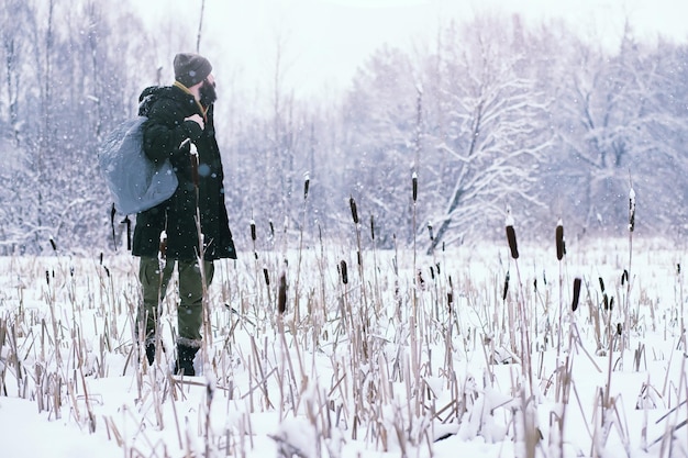 Hombre barbudo en el bosque de invierno. Atractivo joven feliz con barba caminar en el parque.