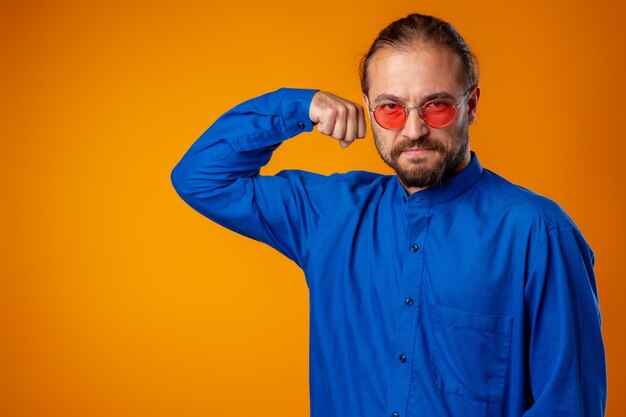 Hombre barbudo en camisa mostrando bíceps