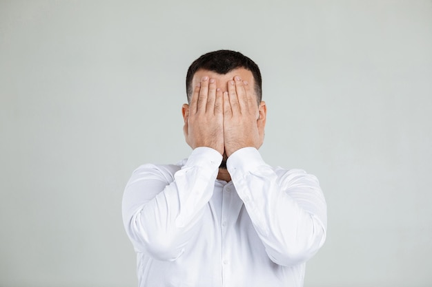 El hombre barbudo cierra los ojos con la mano