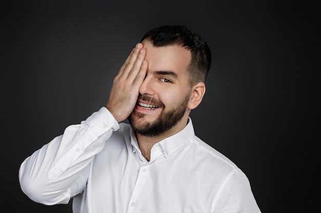 El hombre barbudo cierra los ojos con la mano