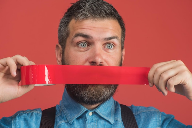 Hombre barbudo con cinta adhesiva envolvente alrededor de la boca empresario silenciado con cinta adhesiva sobre su