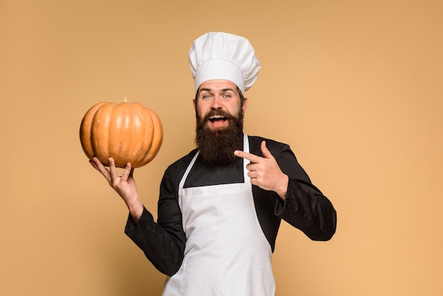 Hombre barbudo cocinero en gorro de cocinero con calabaza feliz halloween verduras útiles cosecha de otoño estacional