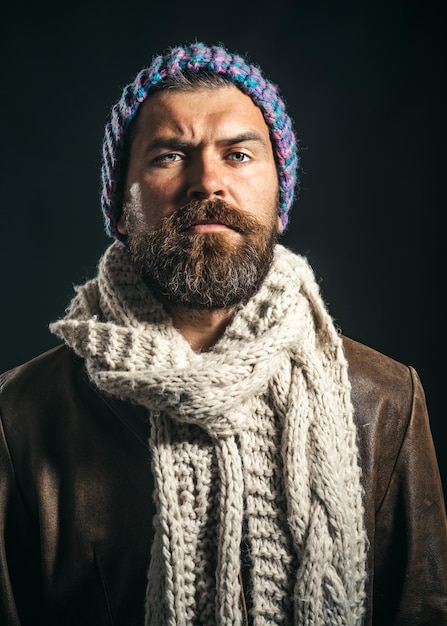 Hombre barbudo confiado de estilo perfecto con sombrero bufanda chaqueta de cuero atractivo macho con barba