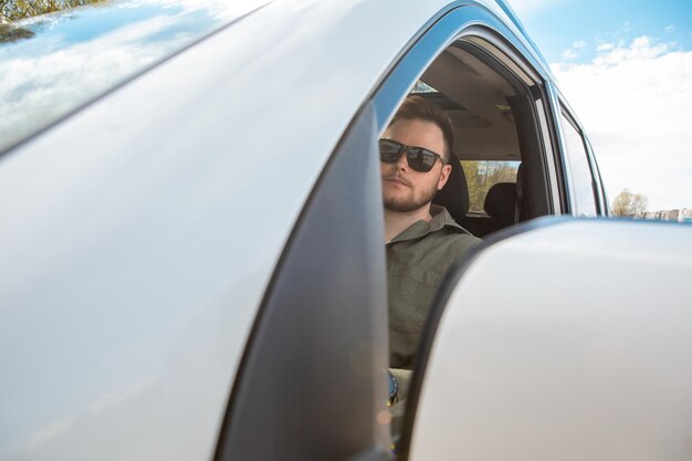 Hombre barbudo dirigiendo el espacio de copia del coche horario de verano