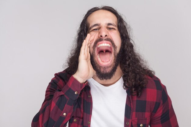 Hombre barbudo emocional sobre fondo gris