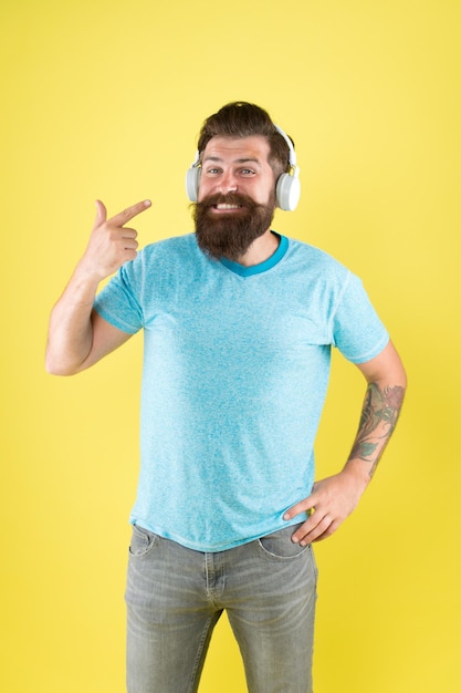 Hombre barbudo escuchando música dispositivo inalámbrico Auriculares inalámbricos diseñados para brindar un sonido limpio La libertad inalámbrica te ofrece un inigualable Hipster feliz usando auriculares inalámbricos modernos