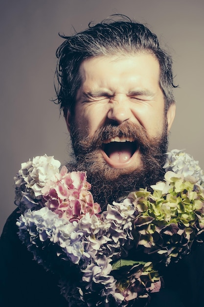 Hombre barbudo con flores de hortensia