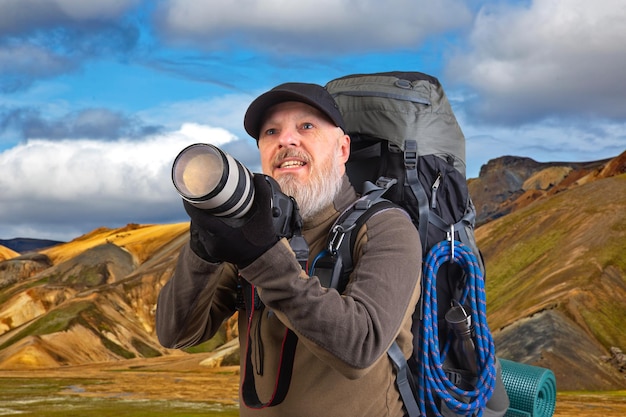 hombre barbudo fotógrafo turístico con una mochila fotografía la belleza de la naturaleza