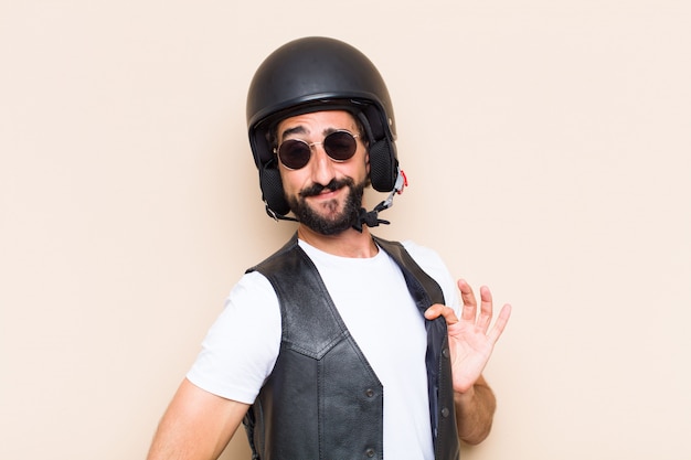 Hombre barbudo fresco joven con un casco mirando exitoso