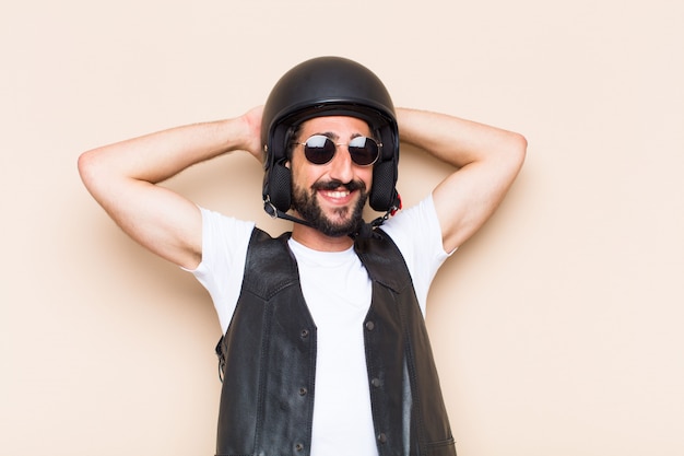 Hombre barbudo fresco joven con un casco mirando exitoso