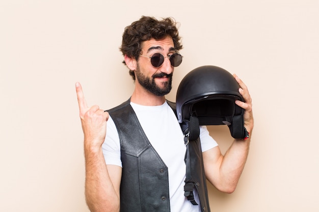 Hombre barbudo fresco joven con un casco mirando exitoso