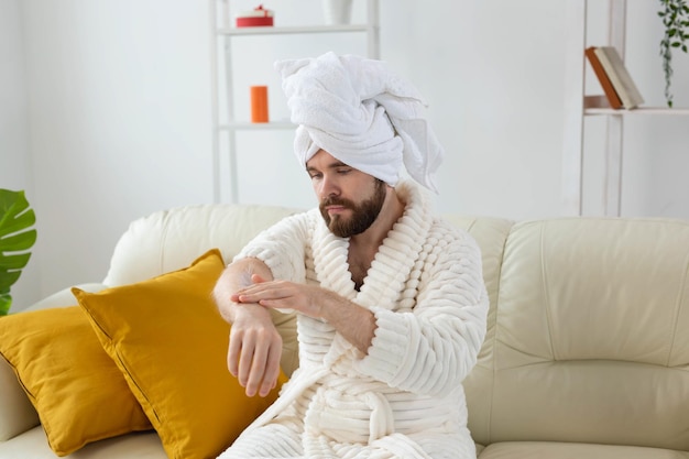 Hombre barbudo se frota las manos con crema de manos. Cuidado de spa, cuerpo y piel para el concepto de hombre