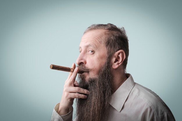 Hombre barbudo fumando un cigarro