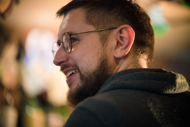 Hombre barbudo con gafas mirando hacia un lado