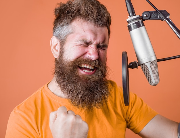 Hombre barbudo gritar en micrófono karaoke hombre cantando con un micrófono cantando en micrófono de estudio