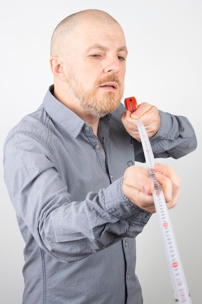 Hombre barbudo hace una cinta métrica centímetro