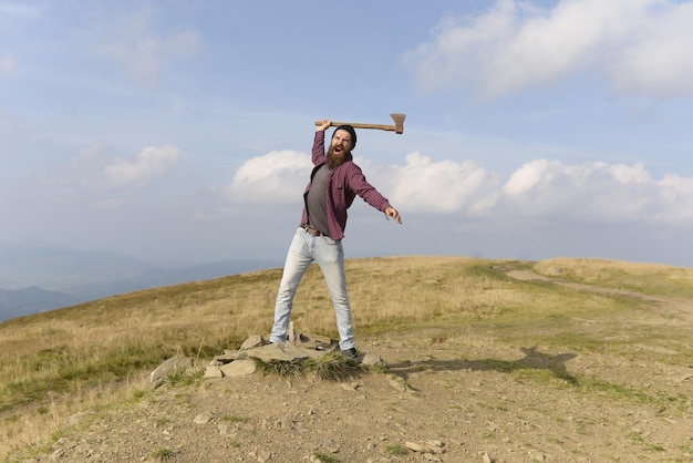 Hombre barbudo con hacha en la montaña