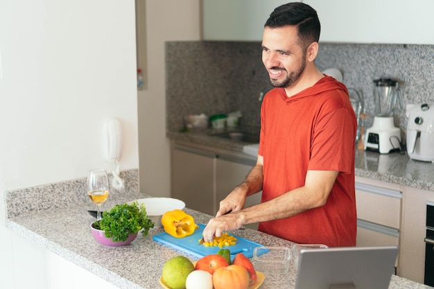 Hombre barbudo haciendo una ensalada en casa