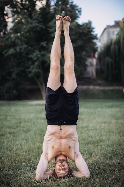 Foto hombre barbudo haciendo yoga en el parque verde