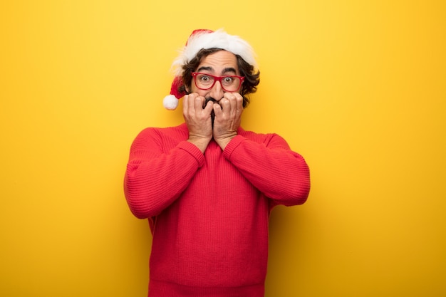 Hombre barbudo loco joven que lleva los vidrios rojos y el sombrero de Papá Noel